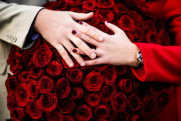 Fotka zásnub s prsteňom a kyticou ruží